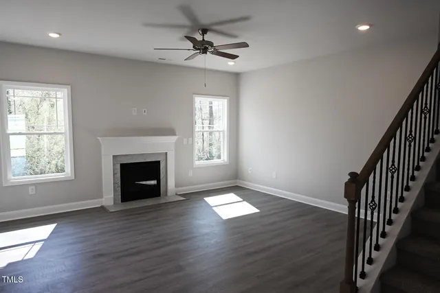 a view of a big room with wooden floor and a kitchen