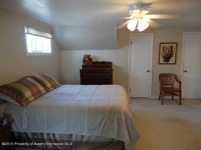 960 Cedar Drive Rifle, CO 81650 - Photo 13 of 27 a bedroom with a bed and a chandelier