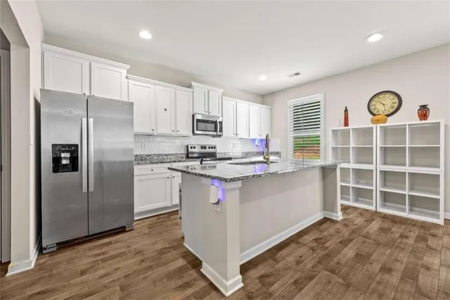 a kitchen with stainless steel appliances a refrigerator sink and microwave