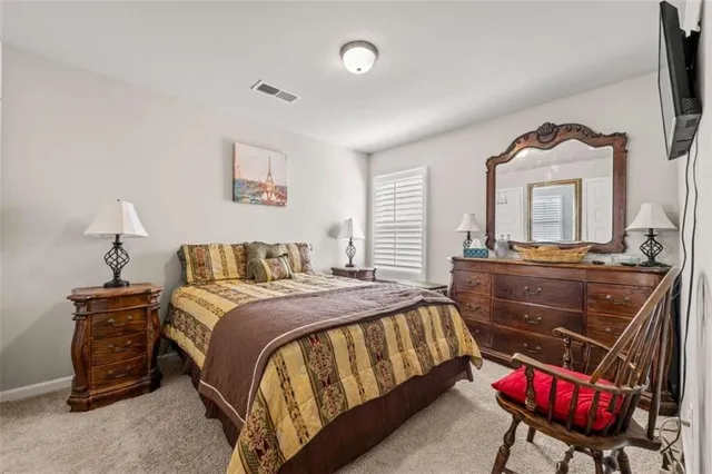 a bedroom with a bed and a dresser with mirror