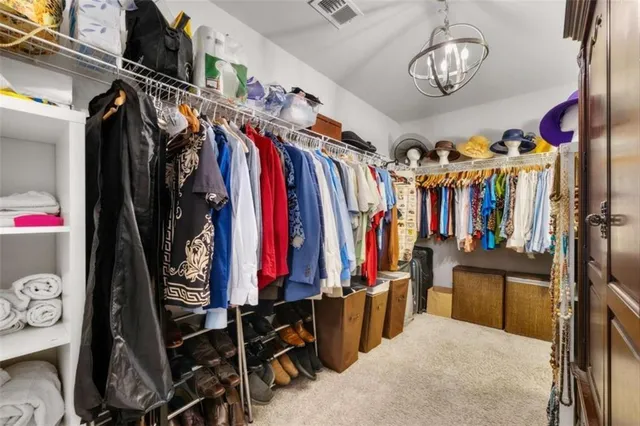 a view of walk in closet with clothes