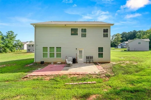 a view of a house with backyard and sitting area