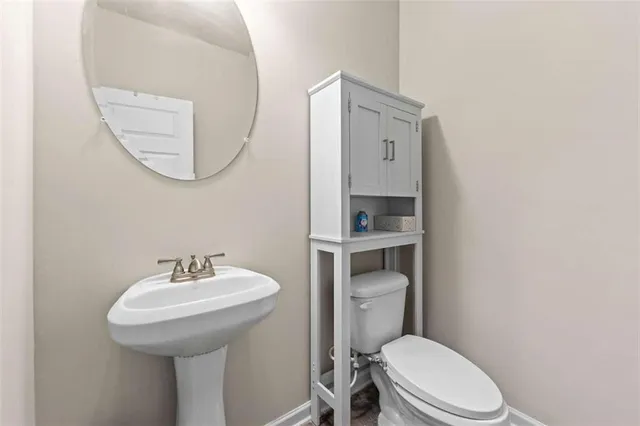 a bathroom with a toilet a sink and mirror