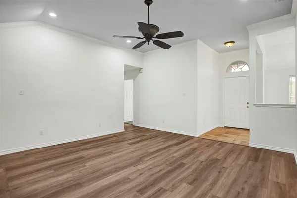 a view of empty room with wooden floor