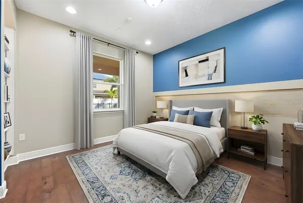 a bedroom with a bed mirror on dresser and a chandelier