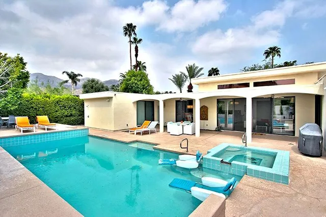 a view of a house with backyard sitting area and garden