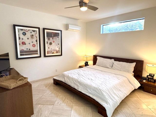 a bedroom with bed and painting on the wall