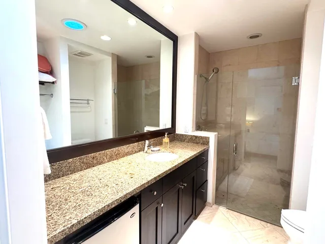 a bathroom with a granite countertop sink and a mirror