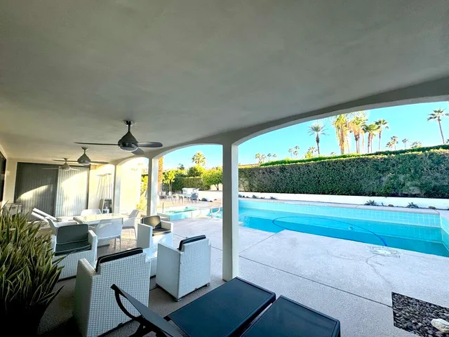 a living room with patio furniture and a garden