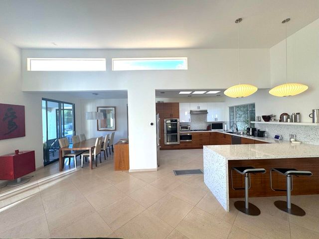 a view of a kitchen with kitchen island dining table and chairs