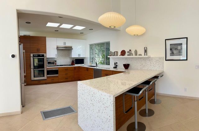 a kitchen with stainless steel appliances granite countertop a sink a stove and a refrigerator