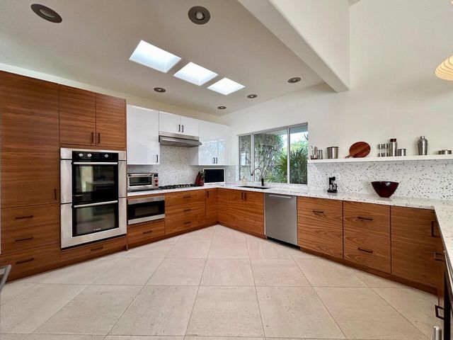a large kitchen with stainless steel appliances granite countertop a sink and cabinets