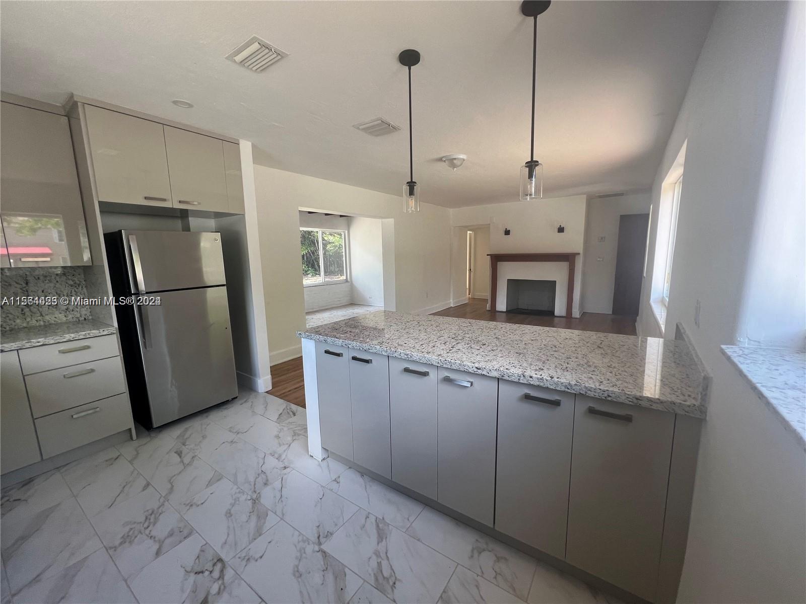245 Southwest 24th Road, Unit 1 Miami, FL 33129 - Photo 13 of 14 a kitchen with stainless steel appliances granite countertop a refrigerator a sink and a stove