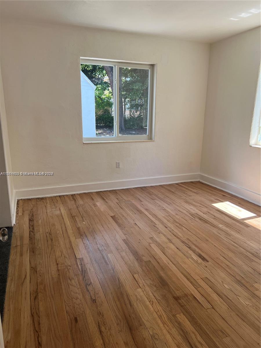 245 Southwest 24th Road, Unit 1 Miami, FL 33129 - Photo 5 of 14 a view of an empty room with wooden floor and a window