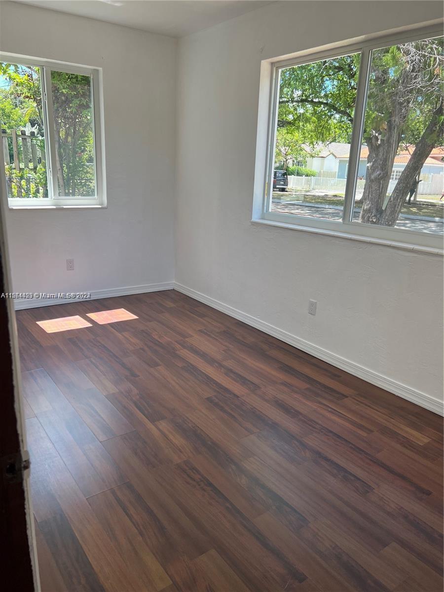 245 Southwest 24th Road, Unit 1 Miami, FL 33129 - Photo 6 of 14 a view of an empty room with wooden floor and a window