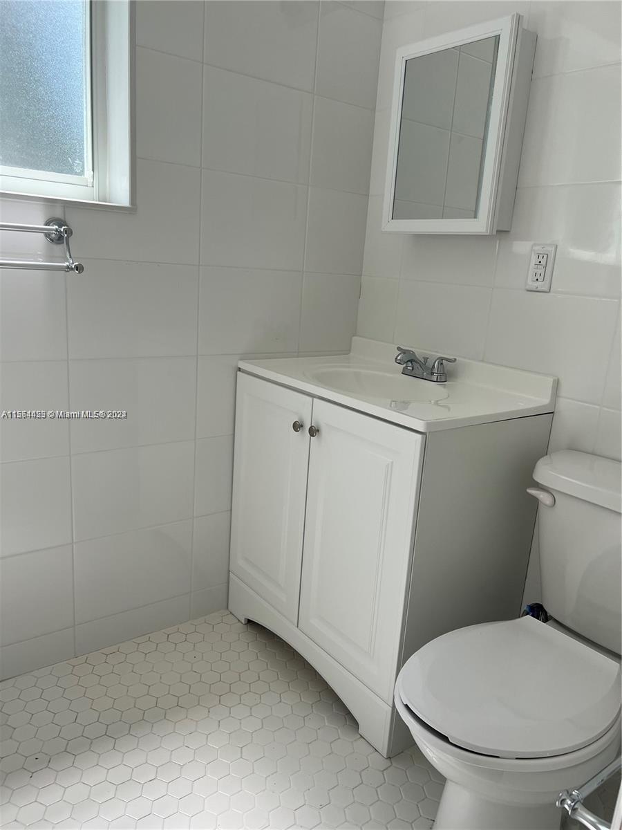 245 Southwest 24th Road, Unit 1 Miami, FL 33129 - Photo 8 of 14 a white toilet sitting next to a bathroom sink