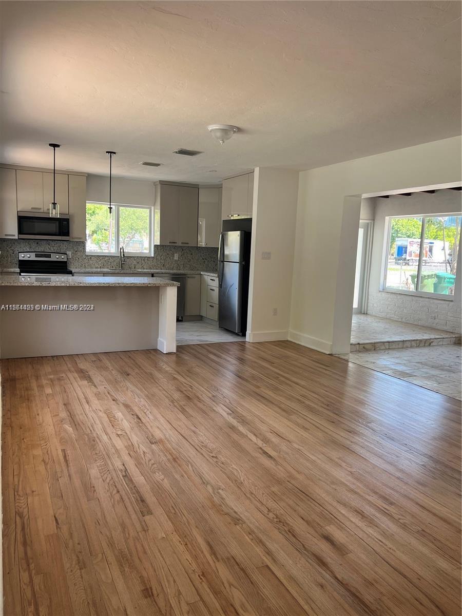 245 Southwest 24th Road, Unit 1 Miami, FL 33129 - Photo 9 of 14 an empty room with wooden floor and windows