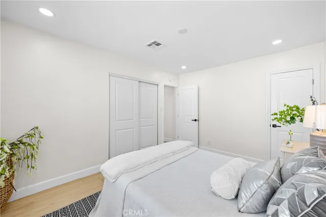 a bedroom with a bed and a potted plant