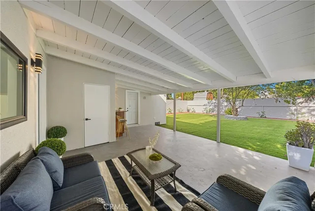 a view of a patio with couches table and chairs with wooden floor