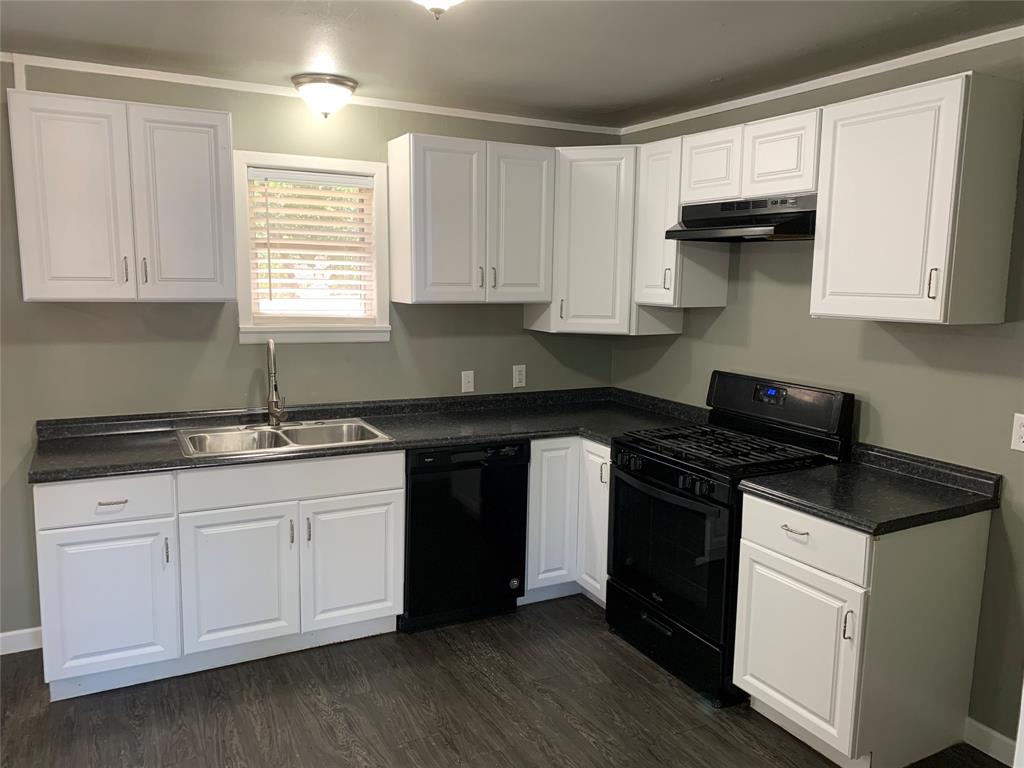 721 Barbara Street Athens, TX 75751 - Photo 6 of 18 a kitchen with granite countertop white cabinets and a stove with wooden floor