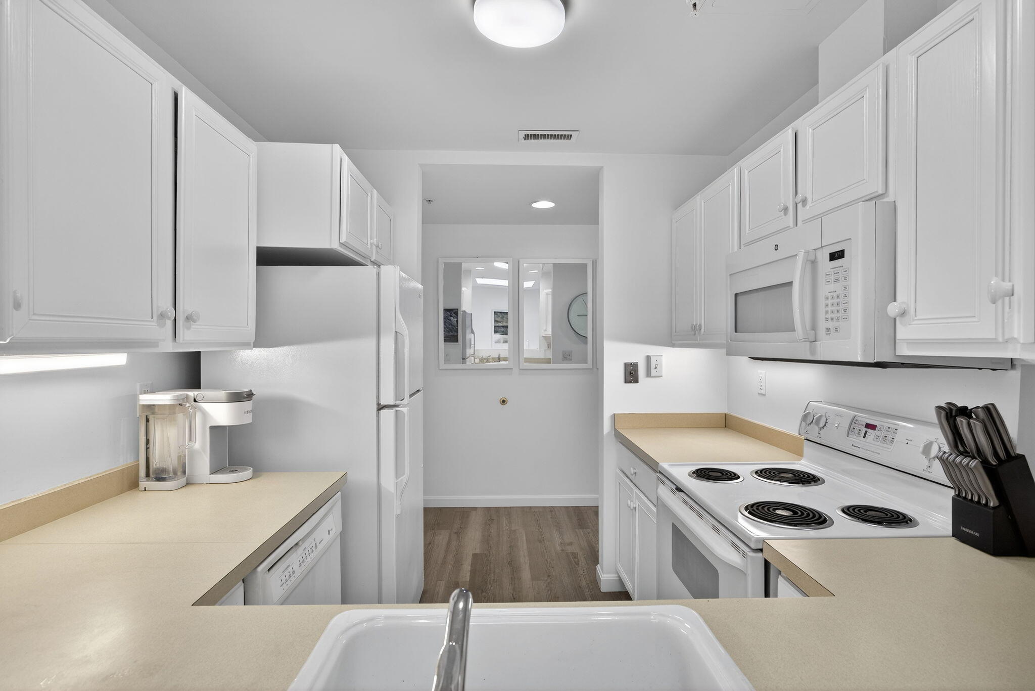 912 Main Street, Unit 308 Chatham, MA 02633 - Photo 26 of 65 a kitchen with white cabinets and appliances