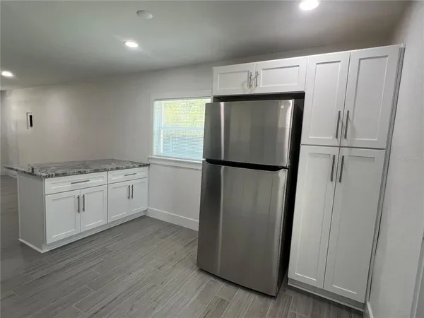 a kitchen with a refrigerator sink stove and cabinets
