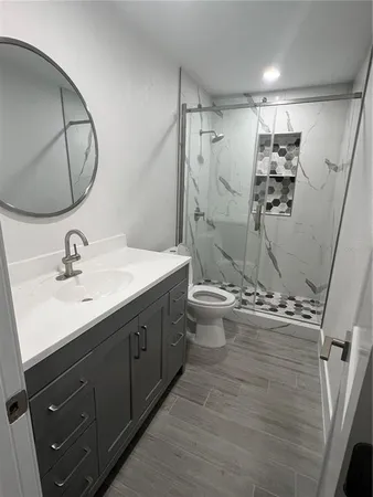 a bathroom with a double vanity sink toilet mirror and shower