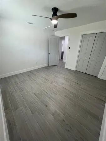 a view of an empty room with wooden floor