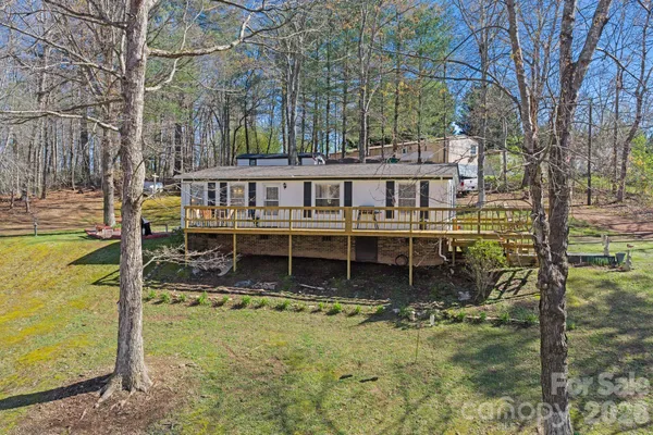 a view of a house with backyard and wooden fence