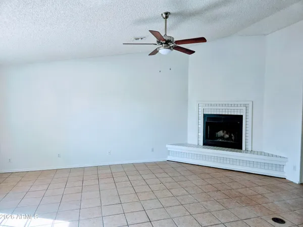 a view of an empty room with a fireplace and a window