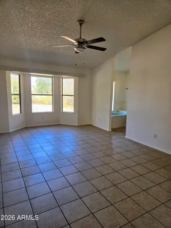 an empty room with windows and fan