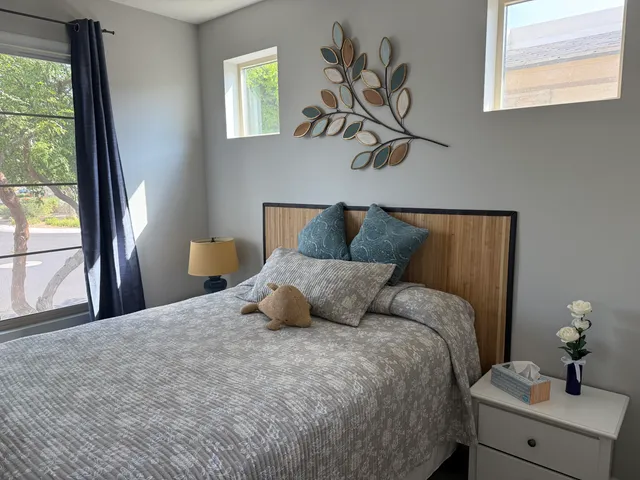 a bedroom with a bed and a large window