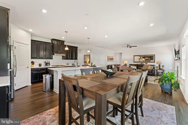 a view of a dining room with furniture wooden floor and a kitchen