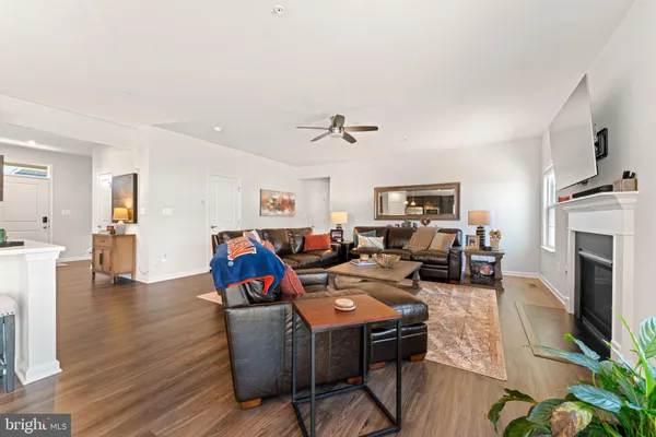 a living room with furniture kitchen view and a fireplace