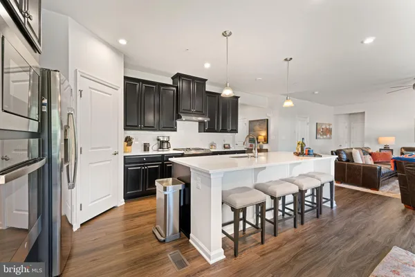 a kitchen with stainless steel appliances granite countertop a sink a stove and a wooden floors