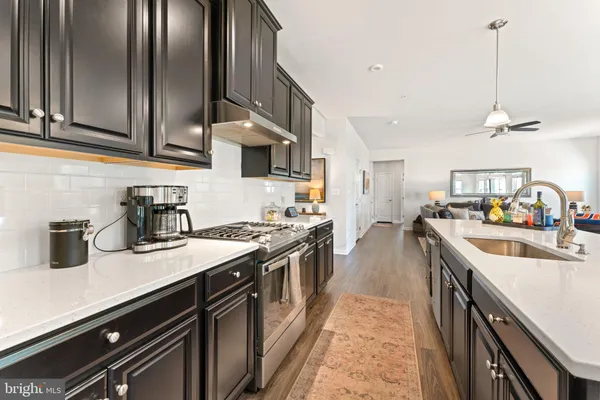 a large kitchen with stainless steel appliances granite countertop a lot of counter space and wooden floors