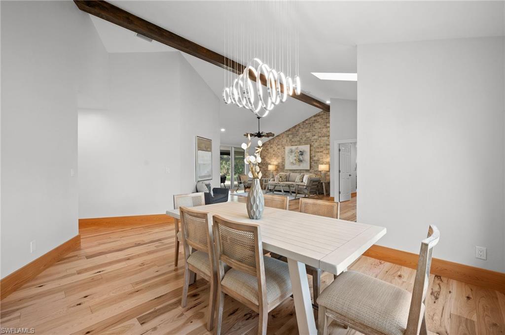 2012 Prince Drive Naples, FL 34110 - Photo 11 of 41 a view of a dining room with furniture a chandelier and wooden floor