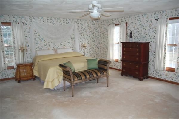 155 East Emerson Road Lexington, MA 02420 - Photo 12 of 18 a spacious bedroom with a bed and a chandelier