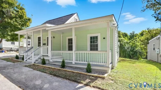 a view of a house with a small yard and wooden fence