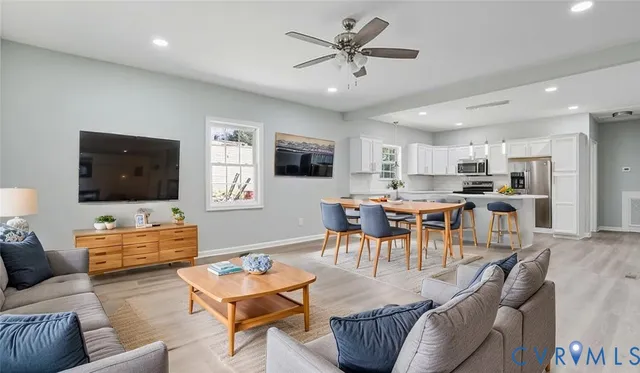 a living room with furniture kitchen view and a flat screen tv