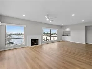 a view of a livingroom with a fireplace wooden floor and window