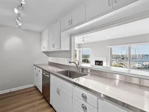 a kitchen with stainless steel appliances granite countertop a sink a stove and a wooden floors