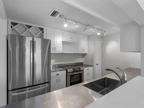 a kitchen with granite countertop a sink stainless steel appliances and cabinets