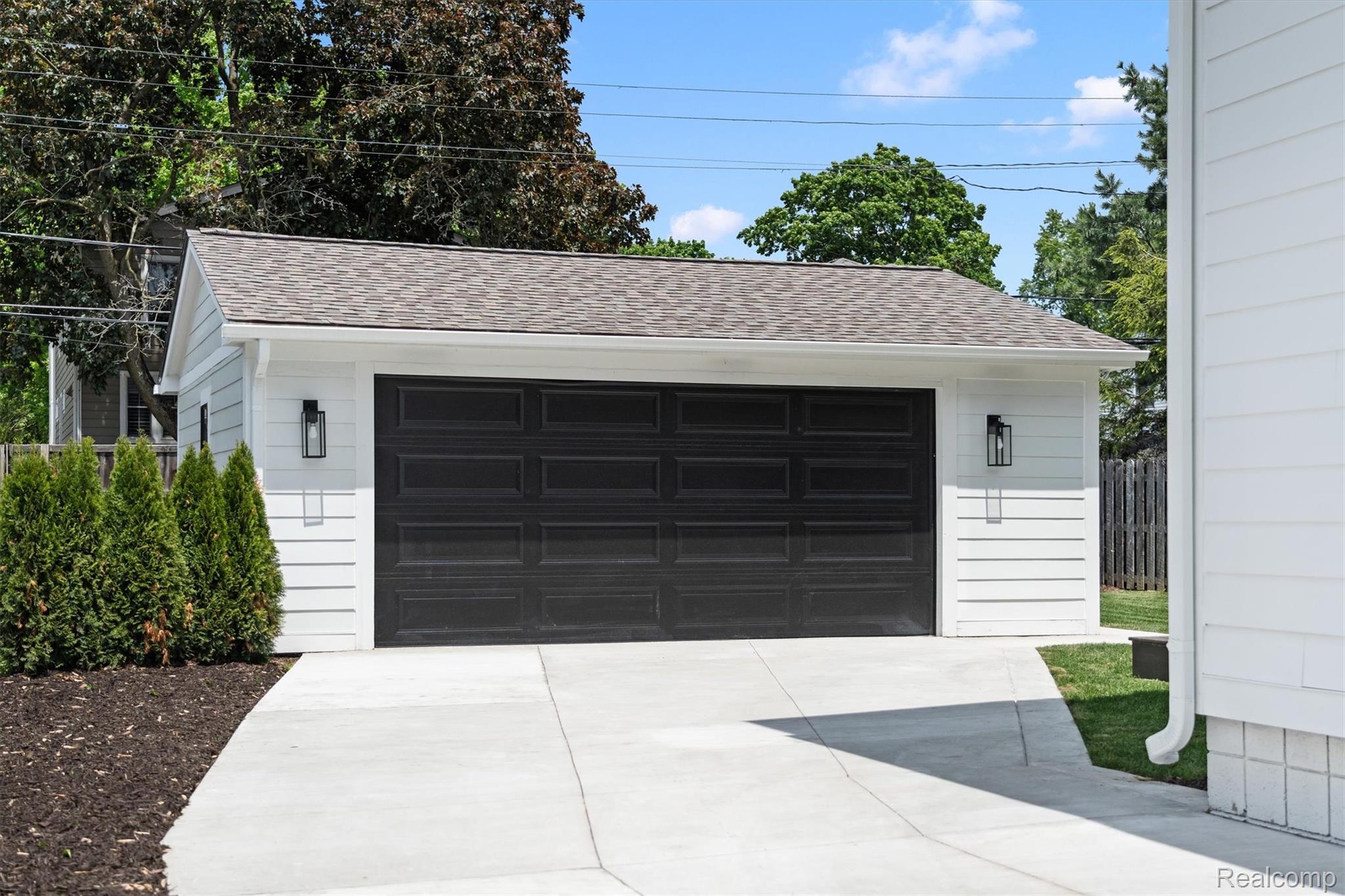 347 Highland Avenue Rochester, MI 48307 - Photo 52 of 59 Detached two-car garage with white horizontal siding and a dark panel garage door