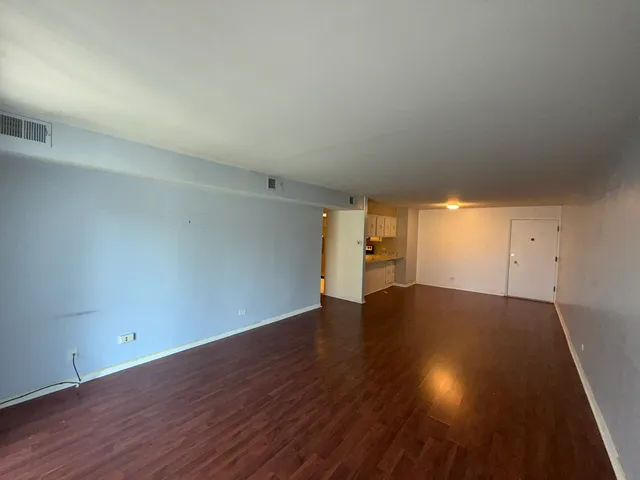 a view of empty room with wooden floor