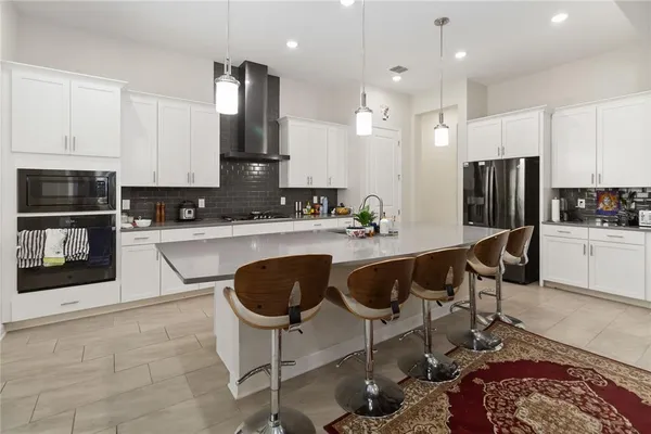 a kitchen with kitchen island granite countertop a stove and a sink