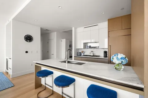 a kitchen with granite countertop cabinets and chairs
