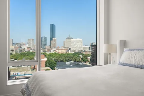 a bedroom with a bed and a large window