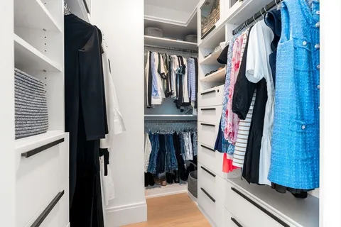 a view of walk in closet with clothes and shoes