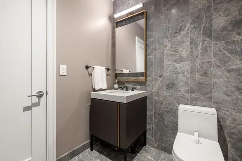 a bathroom with a toilet sink and mirror